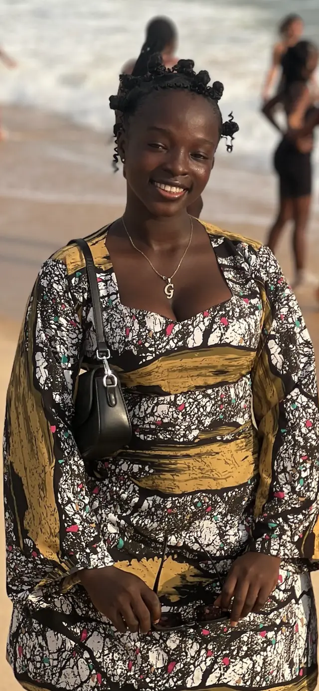 Portrait of the owner of Nymah’s Empire, smiling and wearing a patterned outfit