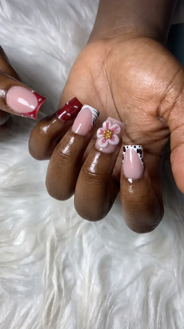 Square nails with a pink and white 3D flower, a leopard-print tip, a pearl-detailed red tip and a zebra-style French tip